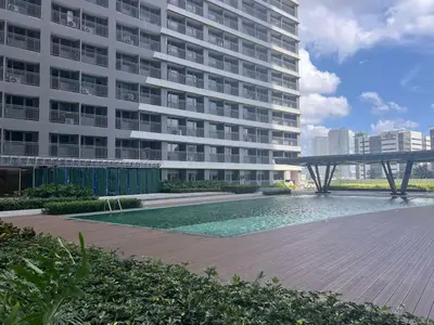 a large building with a swimming pool in front of a building at Ortigas Greenfield Cozy Lodge in Manila