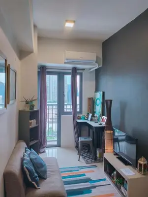 a living room with a couch and a desk at Ortigas Greenfield Cozy Lodge in Manila
