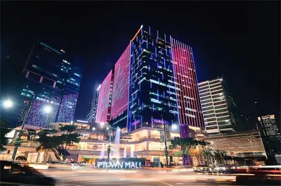 a city at night with a large building with neon lights at Ortigas Greenfield Cozy Lodge in Manila