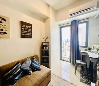 a living room with a couch and a desk at SMDC FAME Apartment in Manila