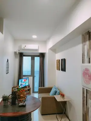 a living room with a couch and a table at SMDC Ortigas FAME in Manila