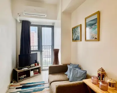 a living room with a couch and a television at SMDC FAME in Ortigas in Manila