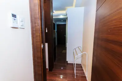 a hallway with a wooden door and a chair at 2 Bedroom Penthouse Air condo Makati Gym Swim Park 300 Mbps in Manila