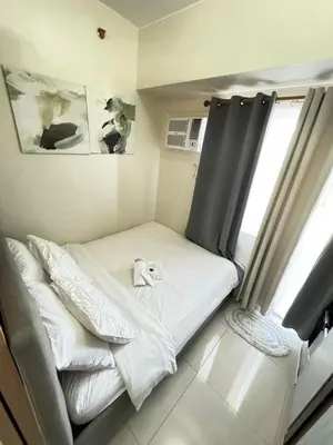 a small bed in a room with a window at Staycation at Field Residences Near Airport in Manila