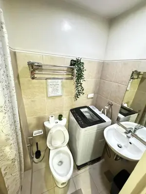 a bathroom with a toilet and a sink at Staycation at Field Residences Near Airport in Manila