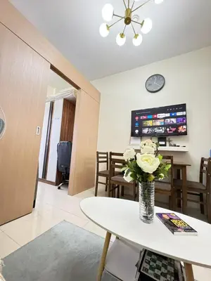 a living room with a vase of flowers on a table at Staycation at Field Residences Near Airport in Manila
