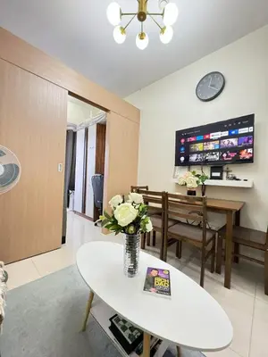 a living room with a vase of flowers on a table at Staycation at Field Residences Near Airport in Manila