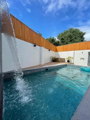 a swimming pool with a water fountain at Cozy Private Resort with Pool, Hijas Villa Binangonan in Binangonan