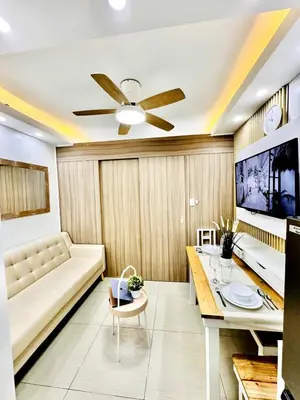 a living room with a couch and a tv at Lotus' Suite in Manila