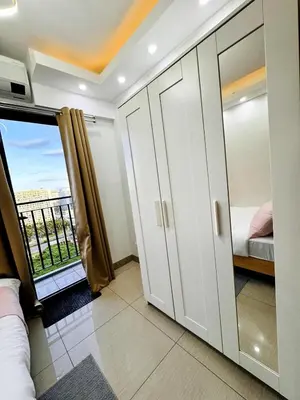 a bedroom with a balcony with a bed and a window at Lotus' Suite in Manila