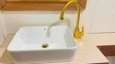 a white sink with a gold faucet in a bathroom at Shore Residence a31 shortwalk Mall of Asia in Manila