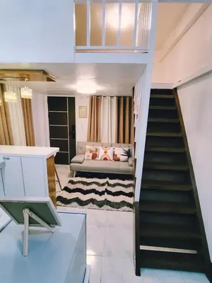 a living room with a staircase and a couch at Aki's Place Binangonan in Binangonan