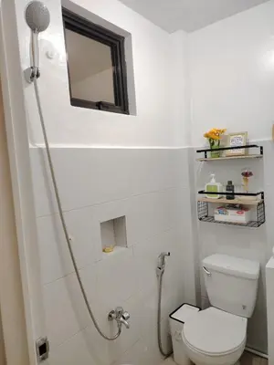 a white bathroom with a toilet and a shower at Aki's Place Binangonan in Binangonan