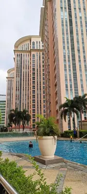 a large building with a potted plant in front of it at Mc Kinley Home Away from Home in Manila