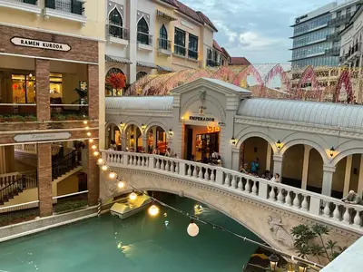 a bridge over a canal in a shopping mall at Mc Kinley Home Away from Home in Manila