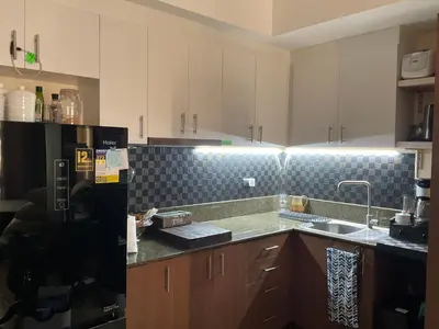 a kitchen with a black refrigerator and a sink at Mc Kinley Home Away from Home in Manila