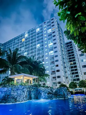 a large building with palm trees in front of it at Seventh Ave in Manila