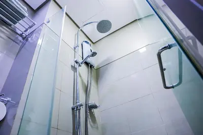 a shower with a glass door in a bathroom at Seventh Ave in Manila
