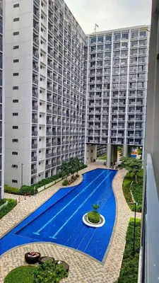 a large building with a swimming pool in front of it at Stylish Condo at Shore 2 Residences near MOA & Airport in Manila
