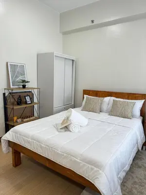 a bedroom with a large white bed with white sheets at The Niall's Suites at HOPE Residences besides SM TRECE in Trece Martires