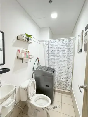 a bathroom with a toilet and a sink at The Niall's Suites at HOPE Residences besides SM TRECE in Trece Martires