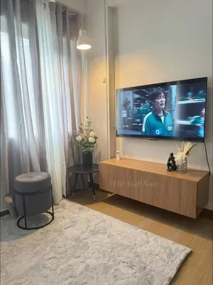 a living room with a large flat screen tv at The Niall's Suites at HOPE Residences besides SM TRECE in Trece Martires
