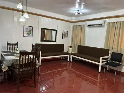 a living room with two couches and a table and chairs at Home in Imus Kawit with free mini pool in Kawit