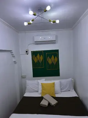 a room with a bed with a yellow pillow at Home in Imus Kawit with free mini pool in Kawit