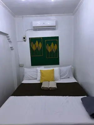 a bedroom with a large bed with two yellow pillows at Home in Imus Kawit with free mini pool in Kawit
