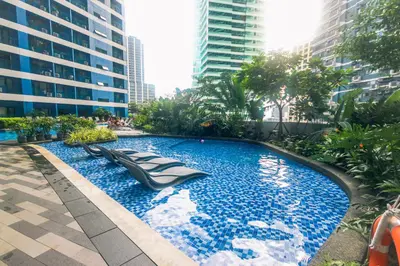 a swimming pool in the middle of a city with tall buildings at Witty Weekend retreat Quirk Cozy in Manila