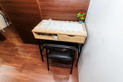 a small table with a chair and a plant on it at Witty Weekend retreat Quirk Cozy in Manila