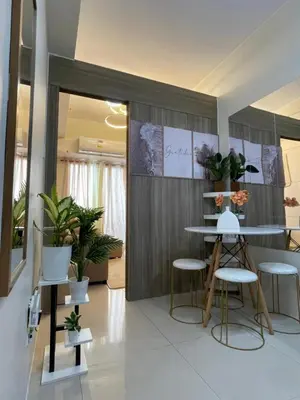 a room with a table and chairs and plants at Elite King Comfort Stay Hotel Apartment - Near Manila Airport in Manila