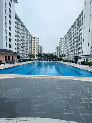 a large swimming pool in front of tall buildings at Elite King Comfort Stay Hotel Apartment - Near Manila Airport in Manila