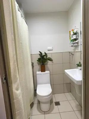 a bathroom with a toilet and a plant on top of it at Elite King Comfort Stay Hotel Apartment - Near Manila Airport in Manila