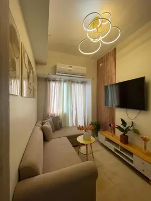 a living room with a couch and a flat screen tv at Elite King Comfort Stay Hotel Apartment - Near Manila Airport in Manila