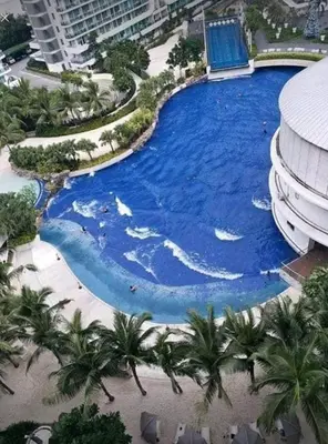 an overhead view of a large swimming pool with palm trees at Azure Urban Resort Residences,BORACAY tower model unit in Manila