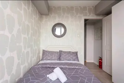 a bedroom with a bed and a mirror on the wall at Azure Urban Resort Residences,BORACAY tower model unit in Manila