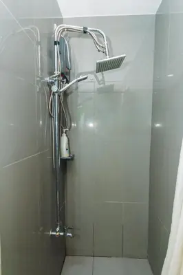 a shower with a shower head in a bathroom at Urban Charm Cozy Meet 60 Air Swim Gym Park 300Mb in Manila