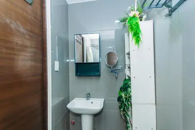 a bathroom with a sink and a mirror at Urban Charm Cozy Meet 60 Air Swim Gym Park 300Mb in Manila
