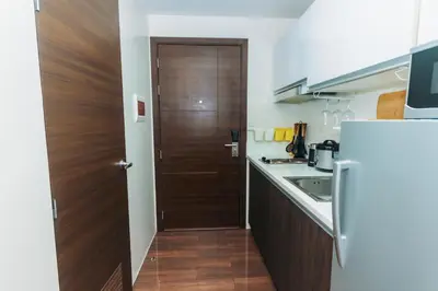 a kitchen with a wooden door and a refrigerator at Urban Charm Cozy Meet 60 Air Swim Gym Park 300Mb in Manila