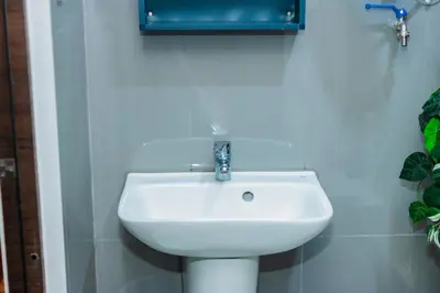 a white sink in a bathroom with a blue mirror at Urban Charm Cozy Meet 60 Air Swim Gym Park 300Mb in Manila
