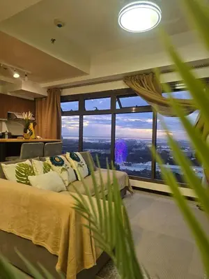 a bedroom with a bed and a large window at The Radiance of Manila Bay in Manila