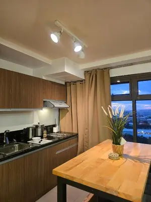 a kitchen with a wooden table and a window at The Radiance of Manila Bay in Manila