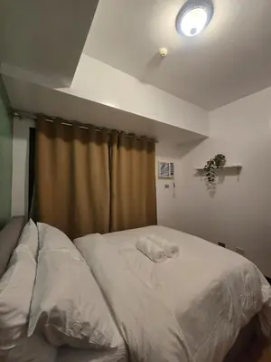 a bedroom with a white bed with a window at The Radiance of Manila Bay in Manila
