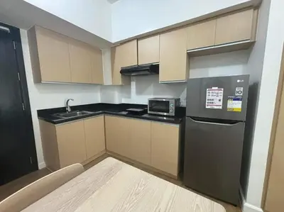 a small kitchen with a refrigerator and a sink at City Front Studio in Manila
