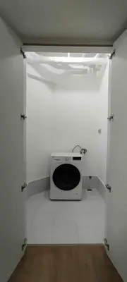a room with a white wall with a microwave at City Front Studio in Manila