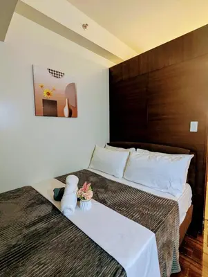 a bedroom with a bed with a teddy bear on it at Charming Comfort 1BR at Air Residences Makati with wifi & netflix in Manila