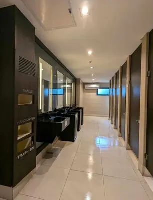 a long hallway with sinks and mirrors in a building at Charming Comfort 1BR at Air Residences Makati with wifi & netflix in Manila