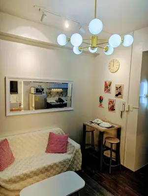 a living room with a couch and a table at Charming Comfort 1BR at Air Residences Makati with wifi & netflix in Manila