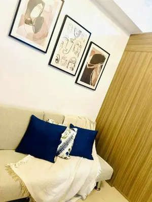 a living room with a couch and pictures on the wall at Cozy Retreat at Shore2 Residences in Manila